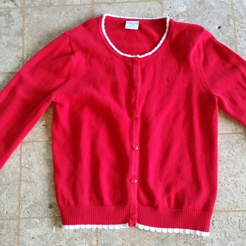 A button-down red sweater with white ruffles.